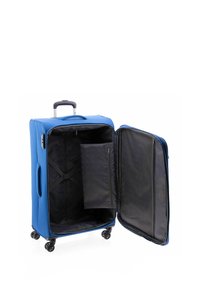 Blauwe koffer met een harde schaal, telescopische hendel, vier wielen en een interieur met zwart stoffen compartimenten en verstelbare riemen.