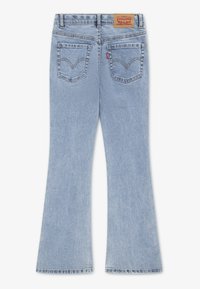 Γαλάζια τζιν με καμπάνα και μέση μεσαίου ύψους, με δερμάτινο πίσω ταμπελάκι, δύο πίσω τσέπες και απαλή ξεθωριασμένη υφή.