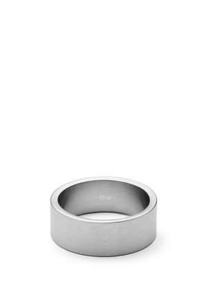 Anillo de banda ancha de metal plateado con acabado cepillado y grabado "DW" en la superficie interior, mostrado contra un fondo blanco.