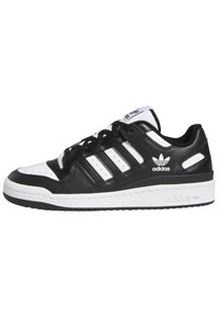 Black and white Adidas low-top sneaker with three stripes, perforated toe box, and branded sole and side logos.