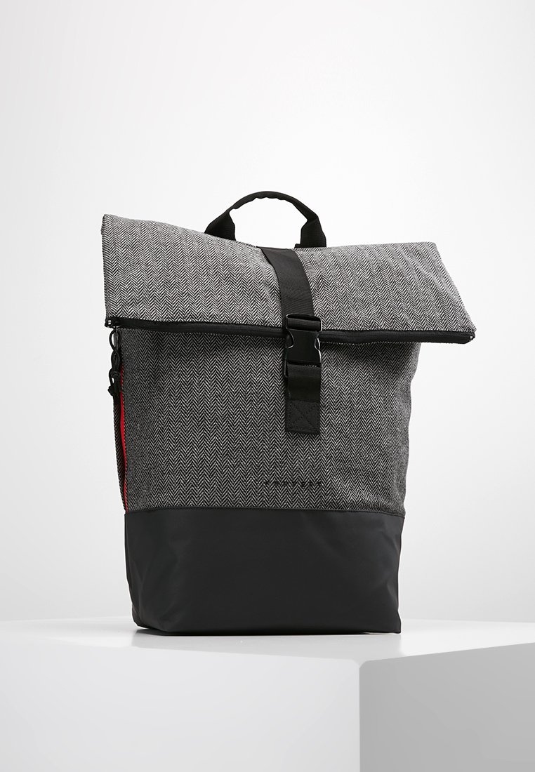 Zaino grigio a spina di pesce con fondo nero, pattina pieghevole e fibbia nera. Presenta un manico corto e chiusura con zip.