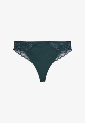 Tanga teal con pizzo in corrispondenza della vita, caratterizzato da un bordo a onde. Tessuto liscio con una finitura leggermente lucida e senza ulteriori motivi.