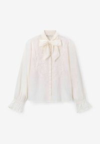 Cream blouse with a bow tie collar, lace detailing on front, and flared sleeves with gathered cuffs, crafted from lightweight fabric.