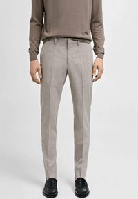 Lys grå skræddersyet bukser med lodrette striber, tekstureret stof og slim fit. Båret med en brun langærmet skjorte og sorte sko.