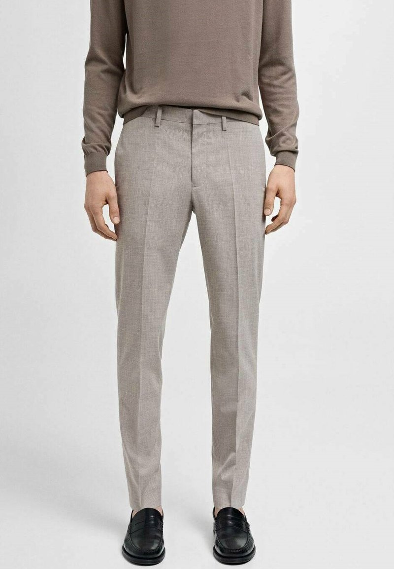 Lys grå skræddersyet bukser med lodrette striber, tekstureret stof og slim fit. Båret med en brun langærmet skjorte og sorte sko.