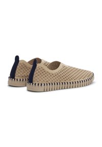 Chaussures beige à enfiler avec texture à motif ondulé, perforations pour la respirabilité, languettes de talon bleu marine et coutures épaisses et flexibles sur la semelle.