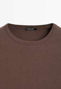T-shirt marron à col rond avec une étiquette noire visible à l'intérieur du col indiquant "Massimo Dutti Made in Portugal."