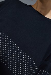 Svart sweatshirt med en gradient av silverstrass på ena sidan, med en mjuk textur och avslappnad design.