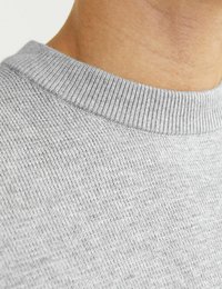 Nahaufnahme eines grauen Strickstoffs mit rippendem Rundhalsausschnitt und glatter Textur, die feine Webdetails und eine einheitliche Farbe hervorhebt.