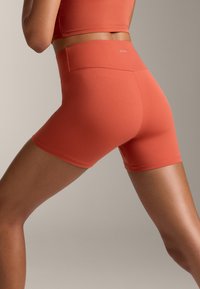 Magas derekú, puha, rugalmas terrakotta szövetből készült sort. Seamless derékpánt és testhezálló kialakítás jellemzi, tökéletes aktív viselethez.
