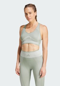 Ljusgrön sport-bh och hög midja leggings med geometriska mönster och en texturerad yta, designade för atletisk användning.