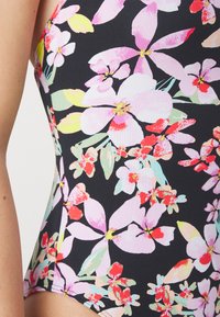 Maillot de bain noir avec un imprimé floral coloré comportant des fleurs roses, rouges et vertes. Fabriqué en tissu extensible, avec une texture lisse et une coupe ajustée.