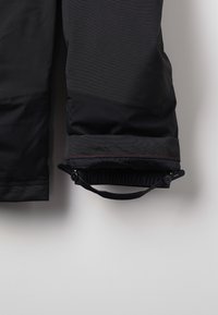 Schwarze, isolierte Skihosen mit gerippter Textur, verstellbaren elastischen Bündchen und einem Kordelzug im Knöchelbereich für einen sicheren Sitz.