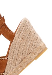 Bruine suède wedge sandaal met een textuur jute hak, voorzien van een gevlochten ontwerp en een gladde rubberen zool. Verfraaid met decoratieve details.
