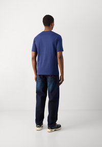 Blå kortermet t-skjorte laget av bomull, kombinert med mørkeblå jeans. Antrekket har en avslappet passform og minimalistisk design.