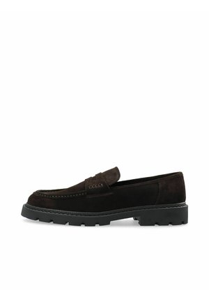 Donkerbruine suède loafer met dikke zwarte rubberen zool en moc toe stiksel, zijaanzicht op witte achtergrond.
