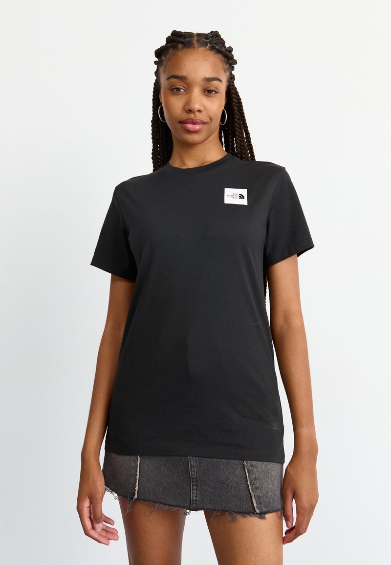 Tricou din bumbac negru, cu guler rotund, mâneci scurte, având un mic patch cu logo alb pe partea stângă a pieptului. Asortat cu o fustă din denim zdrențuită.