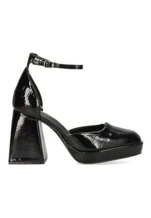 Zapatos de plataforma de charol negros con un tacón grueso, tiras para el tobillo y punta redondeada, que presentan una superficie texturizada y un acabado brillante.