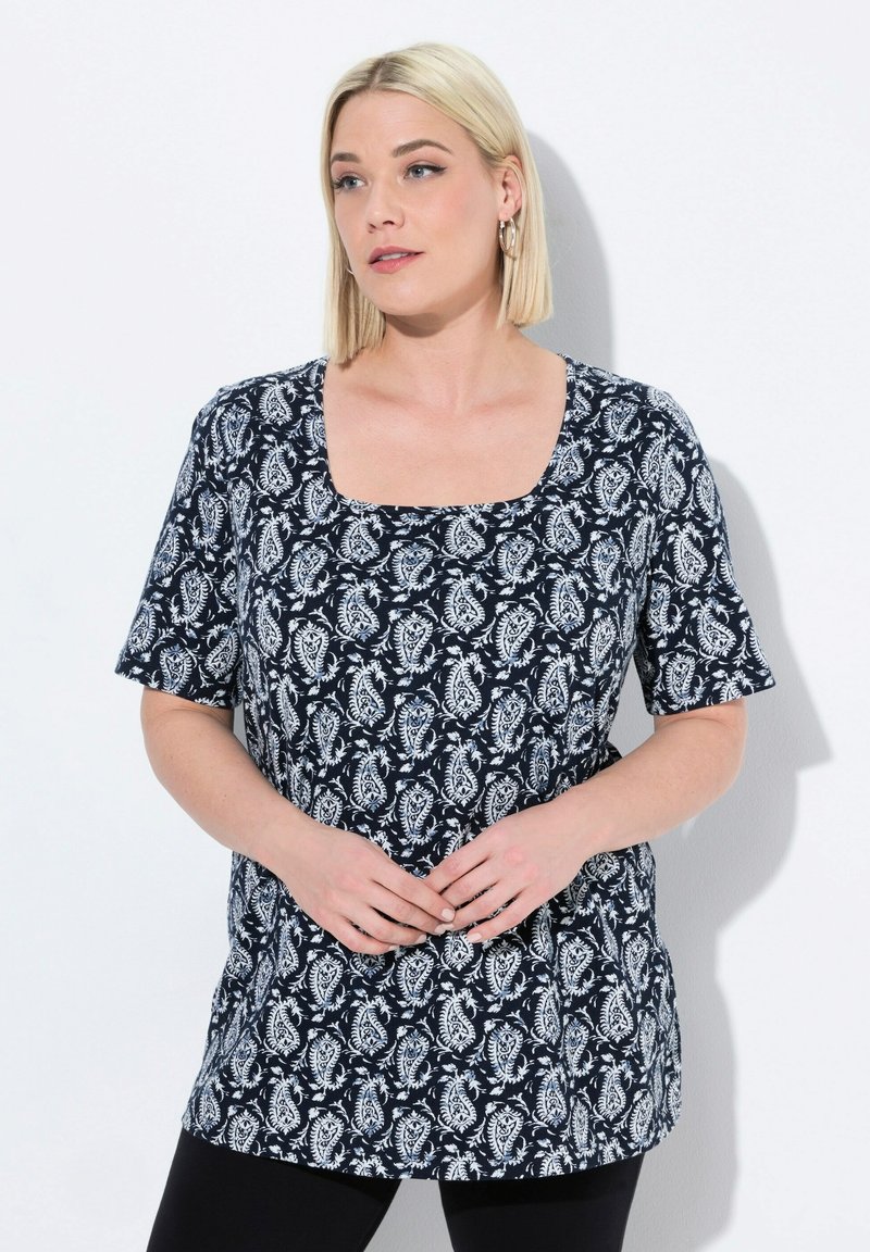 Túnica de manga corta azul marino con escote cuadrado, presenta un patrón de paisley blanco y un corte relajado. Textura suave, llega a la cadera.