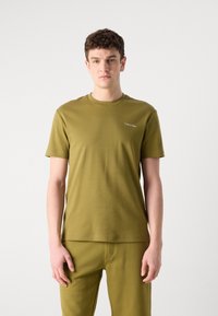 Tricou de bumbac de culoare verde măsliniu, cu gât de tip crew neck și mâneci scurte. Logo-ul "Calvin Klein" brodat în alb pe pieptul din stânga.