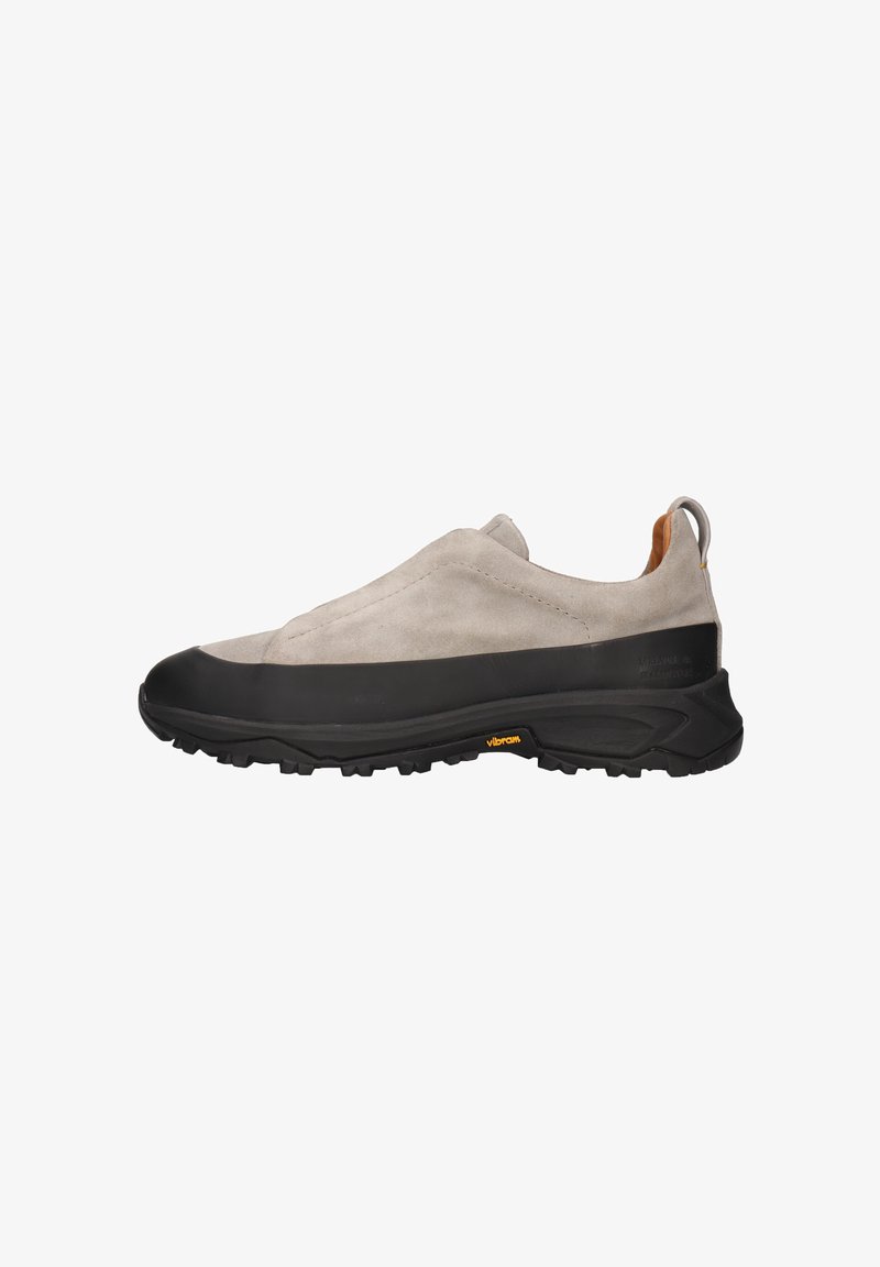 Zapatillas sin cordones con un upper de ante gris claro y una suela de goma negra. Presentan una suela texturizada y una pestaña en el talón.