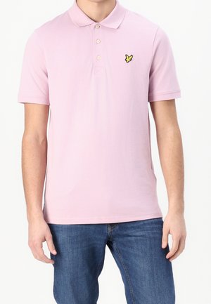 Lichtroze polo gemaakt van katoen, met een drieknoopssluiting en een geel geborduurd logo op de linkerborst. Korte mouwen.