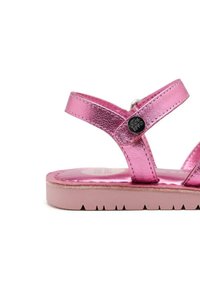 Sandalo con cinturino metallico rosa e suola piatta in gomma, caratterizzato da due cinturini incrociati, un accento con logo circolare e plantare testurizzato.