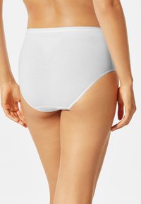 Slip bianchi in cotone a vita alta, con una superficie liscia e un elastico in vita, caratterizzati da un design semplice e senza motivi visibili.