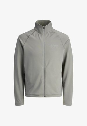 Světle šedá zipová bunda s vysokým límcem, vyrobená z texturované tkaniny. Na levém horním rohu se nachází logo "CNZ".