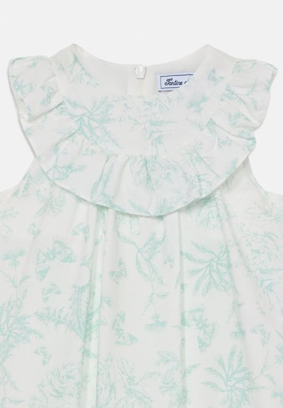 Floral-patterned sleeveless dress in light mint green, featuring a ruffled neckline and a back zipper closure. Soft fabric texture.