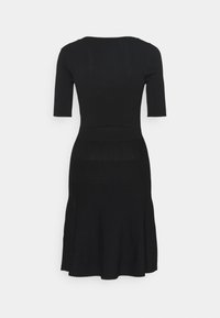 Robe en maille côtelée noire avec manches courtes, corsage ajusté et jupe évasée. Design simple, texture lisse, sans éléments métalliques visibles ni ornements.