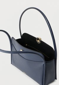 Temno modra usnjena torbica z dvema tankima naramnicama, prednjim žepom, odprtim vrhom z zlatim zaponkom in notranjim žepom z zadrgo.