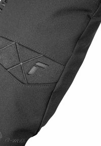 Schwarzer Stoff mit strukturierten Akzenten und geometrischer Steppung; zeigt ein auffälliges Logo in einem subtilen, tonalen Design auf einem Ärmelbereich.