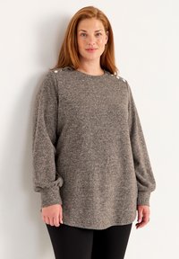 Grijze gebreide trui met lange mouwen, ronde hals en knoopaccenten op de schouders. Zachte textuur en een ontspannen pasvorm, gecombineerd met zwarte broek.