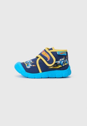Blaue und gelbe Kinderschuhe mit einem weichen Obermaterial, das mit Auto-Graphics bedruckt ist, und einem Klettverschluss für ein einfaches An- und Ausziehen.