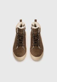 Braune Wildleder-Hochtop-Sneaker mit weicher weißer Innenausstattung, ausgestattet mit Metallösen, Schnürsenkeln und einer strukturierten cremefarbenen Sohle. Reißverschlussdetails an der Seite.