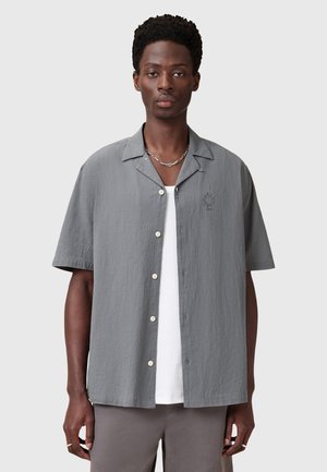 Camicia a maniche corte con bottoni in tessuto grigio chiaro testurizzato, caratterizzata da un colletto a punta e un discreto dettaglio ricamato sul petto.