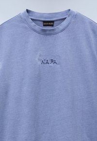 Lichtpaarse katoenen t-shirt met een ronde hals en een getextureerd, geborduurd "NAPA" logo op de borst. Eenvoudige, gladde stof.