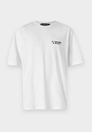 White cotton t-shirt with a crew neckline and short sleeves. Features a black printed logo on the left chest area. Smooth texture.