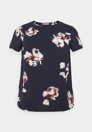 Blouse bleu marine à manches courtes avec imprimé floral rose et blanc, col rond et coupe ample.