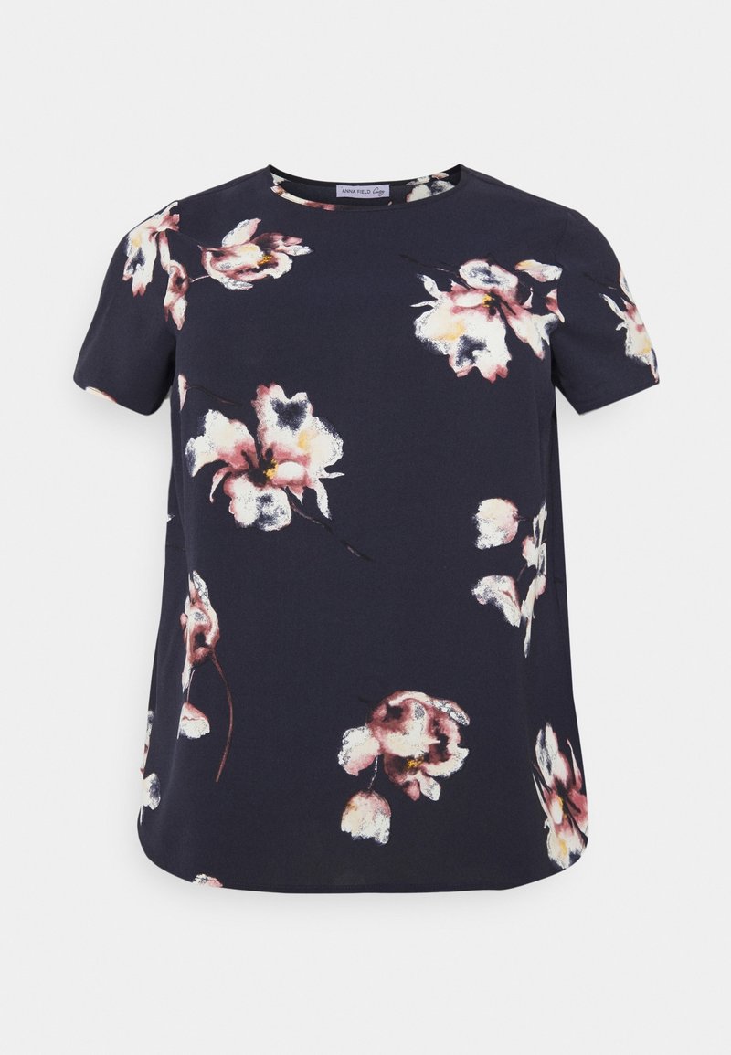 Blouse bleu marine à manches courtes avec imprimé floral rose et blanc, col rond et coupe ample.