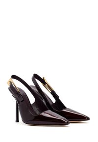 Zapatos de tacón de charol burdeos brillantes con punta afilada, tacones de aguja delgados y detalles en tono dorado.