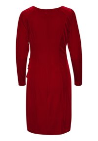 Robe en velours rouge avec des manches longues, décolleté arrondi et ruché sur le côté. Texture lisse et design ajusté se resserrant à la taille.