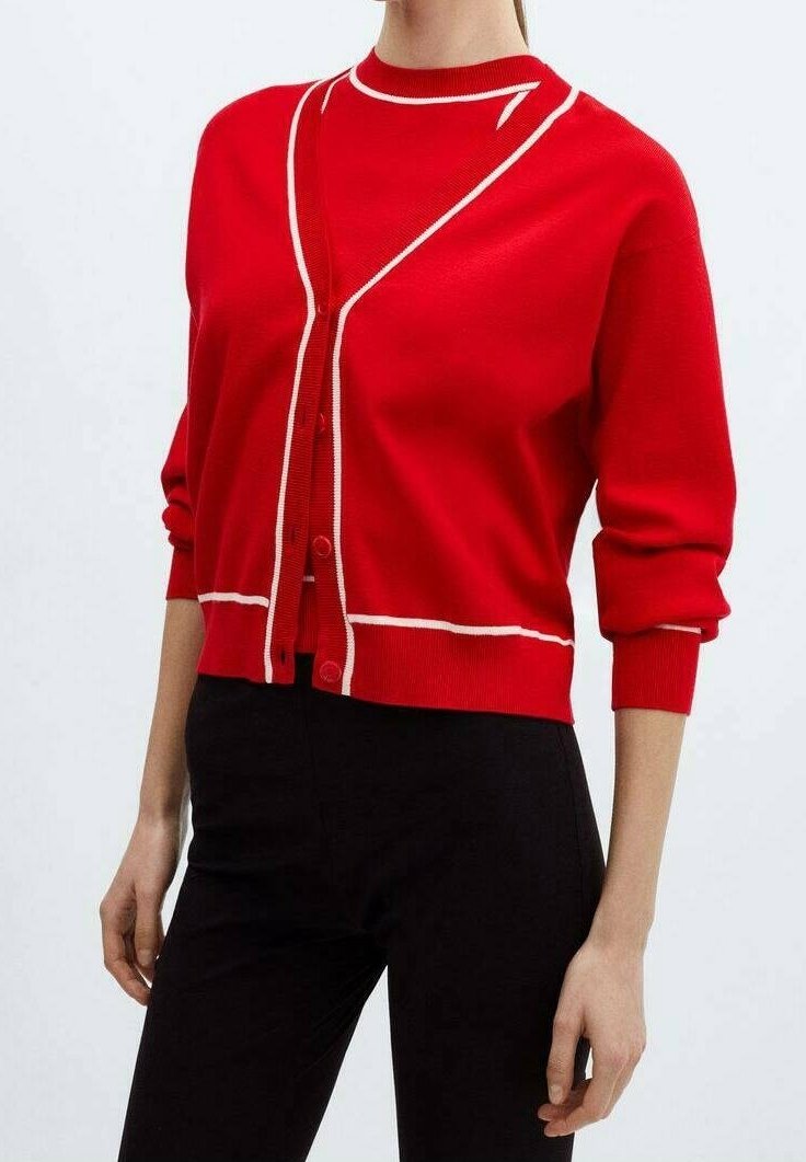Cardigan rouge à boutons avec détails en bordure blanche, porté sur un haut rouge assorti, accompagné d'un pantalon noir.