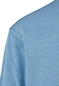 T-shirt in cotone azzurro chiaro con una texture morbida, scollatura rotonda e maniche corte. Dettagli di cucitura visibili nella cucitura della spalla.