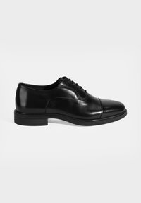 Zwarte leren dress shoe met een gladde afwerking, ronde neus, vetersluiting en een gegroefde rubberen zool. Minimalistische stijl met stiksels.