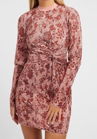 Rotes, floral gemustertes Langarmkleid mit gerippter Textur und einer geknoteten Taillendetail. Mit Rundhalsausschnitt und taillierter Silhouette.