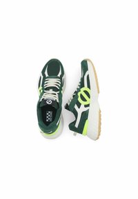 Baskets de sport vertes et blanches en matériau mesh et suède, avec des accents jaunes fluo, une semelle en caoutchouc et des lacets.