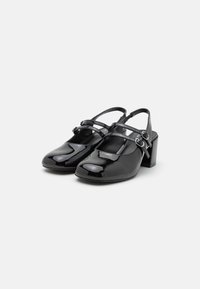 Scarpe slingback in vernice nera con punta arrotondata, due cinturini regolabili sul davanti e tacco medio a blocco.