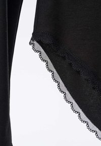 Czarna odzież o miękkiej teksturze, z falbaniastym koronkowym wykończeniem na dole dla dodatkowego detal. 